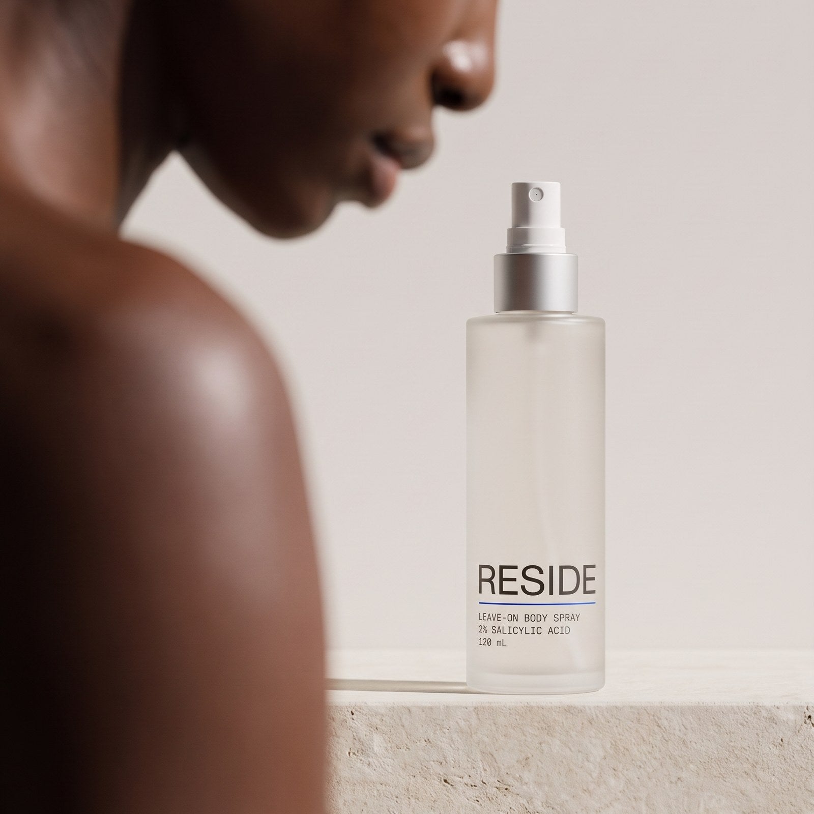 Reside Body Acne Spray on a stone ledge